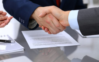 shaking hands and signing agreements